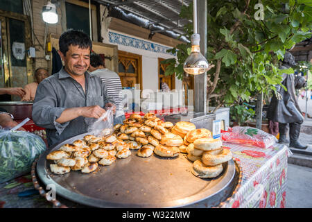 Kashgar, Cina. Xix Apr, 2019. Un uomo vendita gnocchi di agnello presso la storica città vecchia di Kashgar. La provincia dello Xinjiang si trova nella parte nord occidentale della Cina è la più grande provincia in Cina. La maggior parte della popolazione è di religione musulmana nello Xinjiang. Recentemente il governo cinese ha imposto una massiccia repressione di sicurezza nello Xinjiang, dove più di un milione di etnia uiguri e altri per la maggior parte delle minoranze musulmane sono creduti per essere mantenuto in una rete di internamento che Pechino descrive come ''istruzione professionale " centri " destinata a persone dello sterzo lontano dall estremismo religioso. (Cred Foto Stock