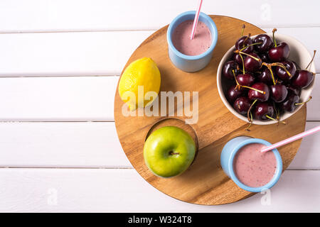 Vista superiore della serie di Superfoods in ciotole , fresco e cherry berry smoothie bianco su sfondo di legno, copia dello spazio. Foto Stock