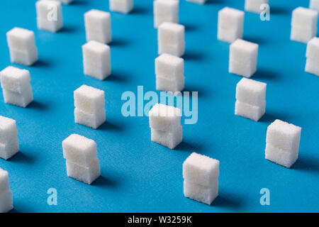 Vista superiore del bianco cubetti di zucchero contro sfondo blu. Stile minimalista. Foto Stock