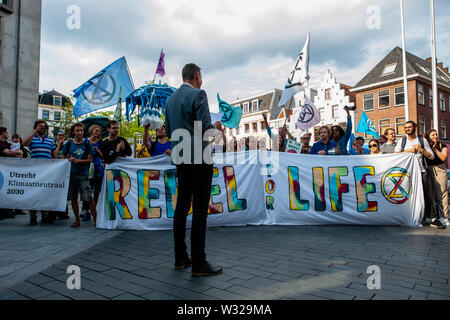 Un membro della PvdD (partito politico per gli animali nei Paesi Bassi) parla durante la protesta.circa trenta persone e gli attivisti si sono riuniti presso il municipio nella città olandese di Utrecht dove alcuni partiti politici stanno andando a votare su una mozione del PvdD (partito politico per gli animali nei Paesi Bassi) per spiegare e dichiarare un emergenza clima nei Paesi Bassi. Al di fuori del municipio è stato circondato dalla polizia, persone che indossano vestiti blu mentre facendo rumore con oggetti diversi, anche urlando a dichiarare un clima di emergenza. Foto Stock