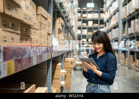 Giovane donna asiatica auditor o partecipante personale alla ricerca di lavoro e verifica il numero di elementi da memorizzare digitale compressa. Asian proprietario o small business conce Foto Stock
