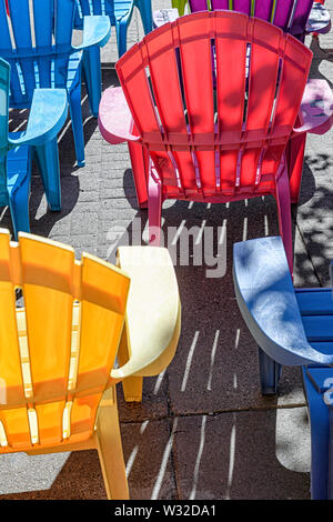 Righe colorate di plastica Sedie Adirondack Foto Stock