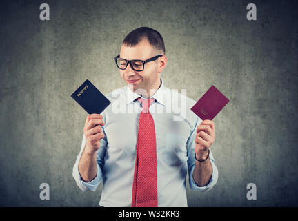 Happy businessman con due passaporti, doppia cittadinanza Foto Stock