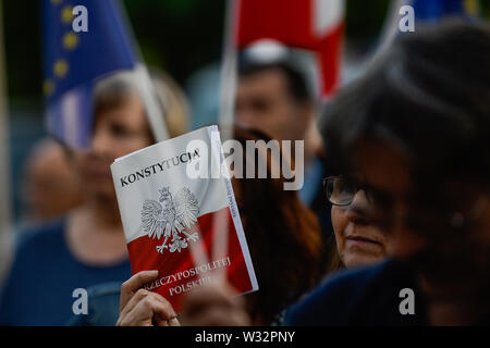 Una donna trattiene una copia della costituzione polacca durante una manifestazione di protesta contro la decisione della procura nazionale su Mariusz Krason, davanti a Cracovia la Corte.Mariusz Krason, Cracovia basa procuratore è stato trasferito a Wroclaw. Egli è stato il promotore di una risoluzione in sede di assemblea generale della direzione regionale dell'Ufficio della Procura di Cracovia, in cui egli ha allarmato dalla minaccia di indipendenza del procuratore europeo. Il 18 luglio, la questione dello stato di diritto in Polonia, ai sensi dell'articolo 7 procedura, verrà discusso nella prossima riunione dei ministri UE. Foto Stock