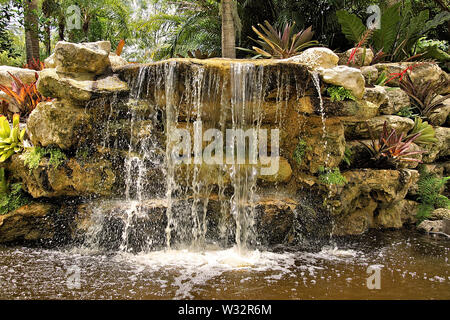 Tranquilla cascata lungo i sentieri attraverso il lussureggiante paesaggio verde con vedute panoramiche Foto Stock