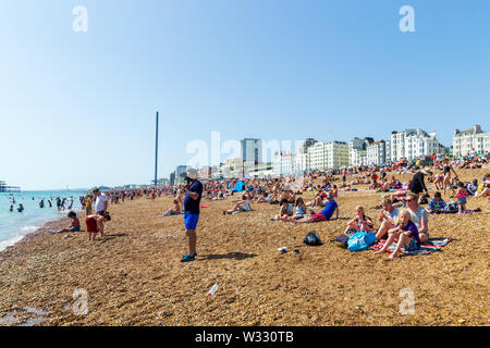 Regno Unito Giugno 29th, 2019 spiaggia di Brighton, Brighton e Hove, East Sussex, Inghilterra. Migliaia di persone rilassarsi su sun. Foto Stock