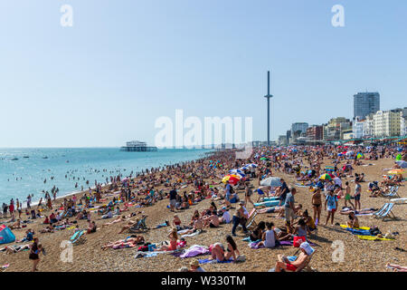 Regno Unito Giugno 29th, 2019 spiaggia di Brighton, Brighton e Hove, East Sussex, Inghilterra. Migliaia di persone rilassarsi su sun. Foto Stock