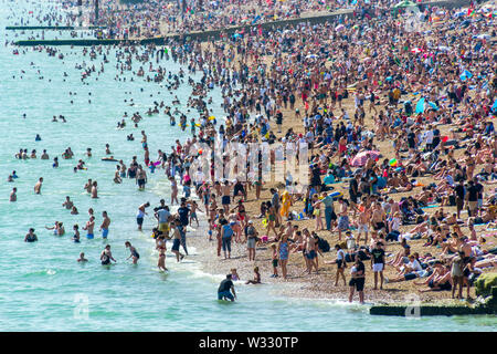 Regno Unito Giugno 29th, 2019 spiaggia di Brighton, Brighton e Hove, East Sussex, Inghilterra. Migliaia di persone rilassarsi su sun. Foto Stock