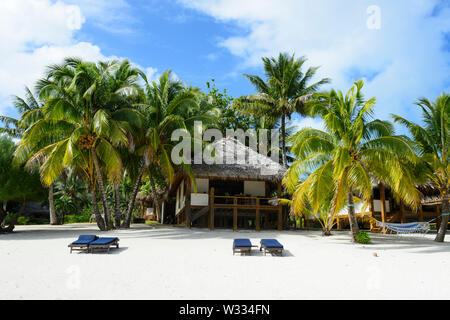 Tetto di Paglia villa su una spiaggia di sabbia bianca e palme di cocco presso il resort di lusso di Etu Moana, Aitutaki, Isole Cook, Polinesia Foto Stock
