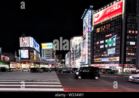 Tokyo, Giappone - Aprile 4, 2019: Shinjuku in centro città con neon luminoso luci di notte con il nero con taxi in movimento sfocato Foto Stock