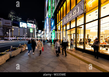 Shinjuku, Giappone - Aprile 4, 2019: Street vista esterna in entrata di Gucci luxury Italian store shop a m quadrato da marciapiede con persone a piedi a nig Foto Stock