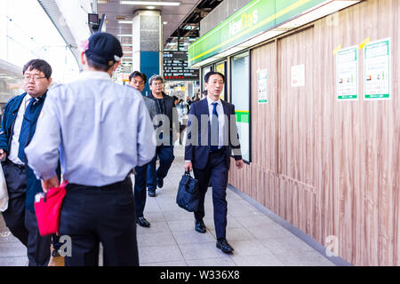 Tokyo, Giappone - Aprile 4, 2019: conduttore giapponese sulla piattaforma della stazione JR di Shinjuku stazione ferroviaria tramite bullet train o shinkansen con la gente di affari busines Foto Stock