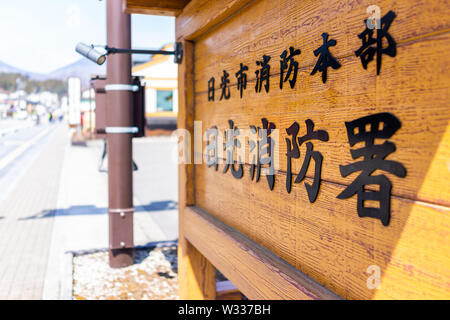 Nikko, Giappone - Aprile 4, 2019: tavola di legno sulla strada del villaggio di montagna con il testo che dice Nikko City Fire Department segno Foto Stock