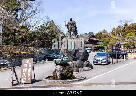 Nikko, Giappone - Aprile 4, 2019: Statua di Shodo Shonin monaco buddista con i serpenti o i serpenti dalla fontana di acqua con tempio Rinnoji edifici Foto Stock