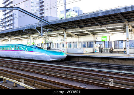 Utsunomiya, Giappone - Aprile 4, 2019: il treno superveloce Shinkansen arrivando alla stazione della piattaforma con la gente di affari, imprenditore in attesa in Tochigi Foto Stock