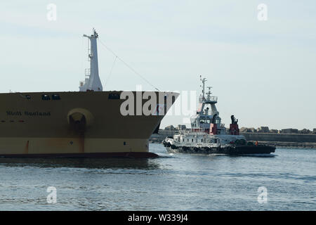 Porti globali, Durban, KwaZulu-Natal, Sudafrica, rimorchiatore che assiste la nave commerciale nel porto, trasporto, industria, movimento, nave, barca, porto Foto Stock