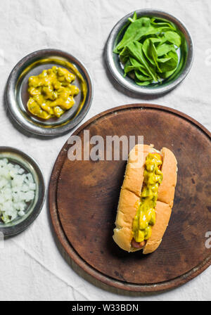 Tradizionali di hot dog con il cetriolino e senape relish contro uno sfondo bianco Foto Stock