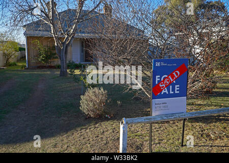 Adesivo venduti attraverso un segno venduti al di fuori di una casa nel Nuovo Galles del Sud settentrionale città di Glen Innes, australia Foto Stock