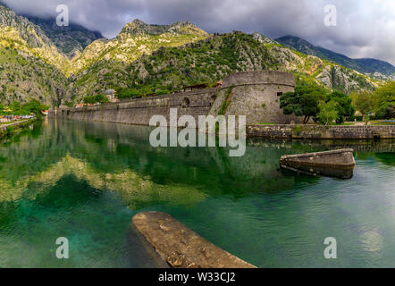 Acque verde smeraldo di Kotor Bay o Boka Kotorska, montagne e le pietre antiche mura della città di Kotor città vecchia ex fortezza veneziana in Montenegro Foto Stock