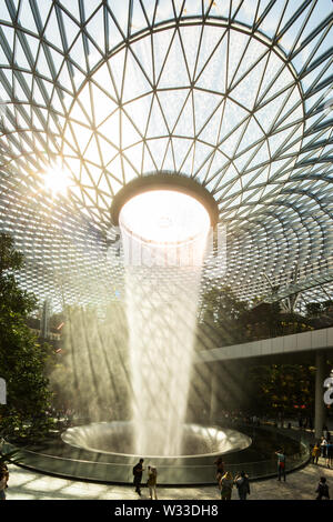 Vista verticale della cascata con una bella luce naturale proveniente in gioiello dell'Aeroporto Changi di Singapore Foto Stock