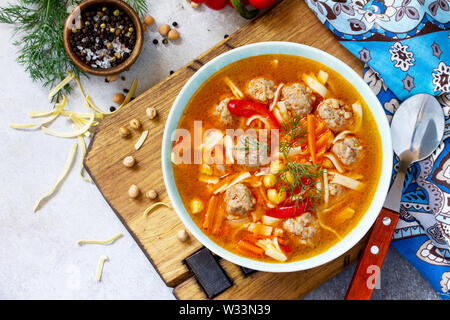 In casa la zuppa calda con pasta, Turchia polpette e Piselli Ceci. Cucina orientale. Il concetto di mangiare sano. Vista superiore piatta sullo sfondo dei laici. Libera Foto Stock