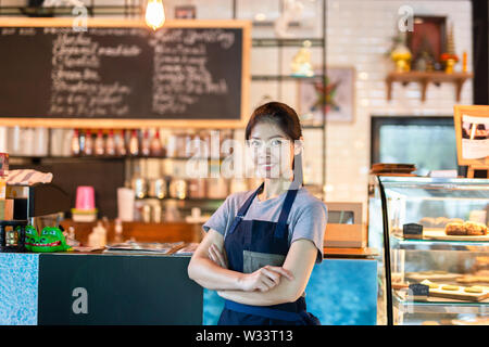 Asian barista donna con sorriso nel coffee shop. Foto Stock