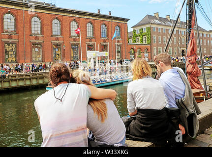 COPENHAGEN, Danimarca - 16 giugno 2019 coppie giovani posto al porto di Nyhavn, famoso porto di Copenaghen costruita nel XVII secolo ora quartiere di intrattenimento Foto Stock