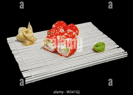 Close-up di sushi e panini al ristorante Cucina. Giapponese cucina tradizionale. California sushi rotoli sul supporto di bambù isolato sul backgr nero Foto Stock