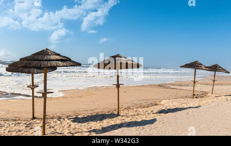 Ombrelloni di paglia in oceano Atlantico Beach, Portogallo Foto Stock