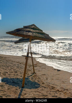 Ombrelloni di paglia in oceano Atlantico Beach, Portogallo Foto Stock