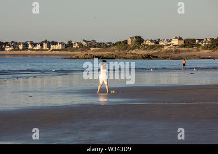 Saint Malo, Francia - 16 Settembre 2018: una donna a praticare yoga sulla spiaggia di Saint Malo nel bagliore del sole al tramonto. Brittany, Francia Foto Stock