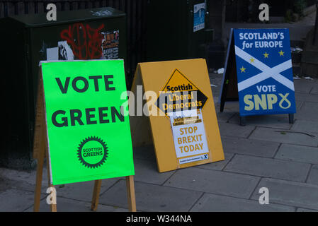 Edimburgo, Scozia / Regno Unito - 23 Maggio 2019: Segni per il Partito dei Verdi, il gruppo del Partito europeo dei liberali democratici e il Partito nazionale scozzese di fronte a p Foto Stock