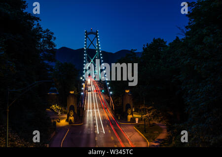 Vista notturna del Ponte Lions Gate con luce sentieri a sinistra passando le vetture Foto Stock