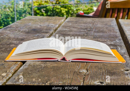 Aprire bokk su un vecchio tavolo in legno per esterno Foto Stock