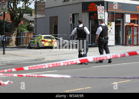 I funzionari di polizia sulla scena di un accoltellato a Barking Road, Newham, a est di Londra. Forze di polizia sono chiamati a circa 0740 venerdì mattina per segnalazioni di un accoltellato e un uomo, credeva di essere nel suo 20s, è stato preso in un est di Londra in ospedale per il trattamento. Foto Stock