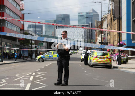 Un funzionario di polizia sulla scena di un accoltellato a Barking Road, Newham, a est di Londra. Forze di polizia sono chiamati a circa 0740 venerdì mattina per segnalazioni di un accoltellato e un uomo, credeva di essere nel suo 20s, è stato preso in un est di Londra in ospedale per il trattamento. Foto Stock