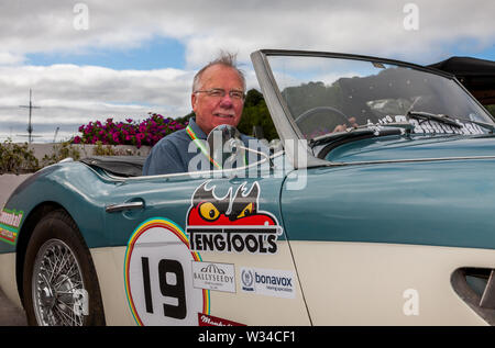 Kinsale, Cork, Irlanda. 12 Luglio, 2019. Kevin Begley con il suo 1960 Austin Healy 3000 MK 1 in corrispondenza della linea di partenza della Cannononball retrò Road Trip a Kinsale, Co. Cork, Irlanda. Il percorso classico inizia a Kinsale e prende in Healy Pass, Kenmare, Molls Gap, pollice Beach, Dingle, Slea Head, Conor Pass, Tralee e termina al Castello di Bunratty il 13 luglio 2019. Credito: David Creedon/Alamy Live News Foto Stock