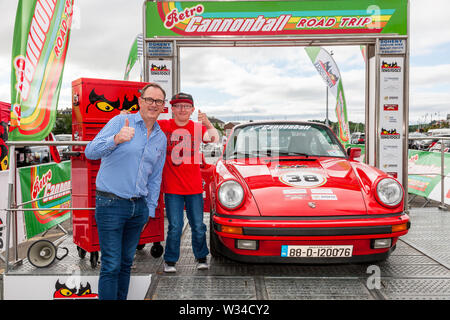 Kinsale, Cork, Irlanda. 12 Luglio, 2019. Cannonball fondatore Alan Bannon e Conor Lunny da Fermanagh presso la linea di partenza della Cannononball retrò Road Trip a Kinsale, Co. Cork, Irlanda. Il percorso classico inizia a Kinsale e prende in Healy Pass, Kenmare, Molls Gap, pollice Beach, Dingle, Slea Head, Conor Pass, Tralee e termina al Castello di Bunratty il 13 luglio 2019. Credito: David Creedon/Alamy Live News Foto Stock