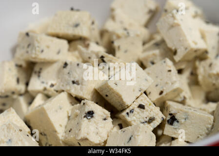 Il tofu cubess con erbe aromatiche in vaso bianco closeup Foto Stock