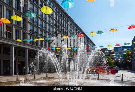 Ombrelloni colorati sospesi attraverso Walter Benjamin Platz a Berlino Foto Stock