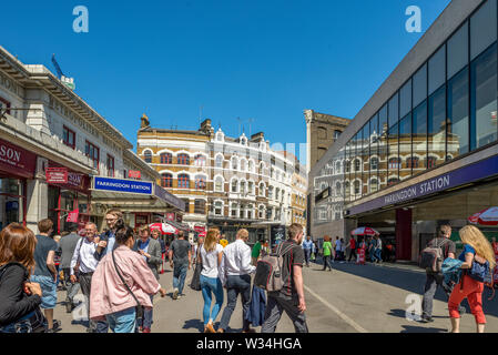 Farringdon Road occupato con pendolari e lavoratori versando di Farringdon stazione della metropolitana in una giornata di sole Foto Stock