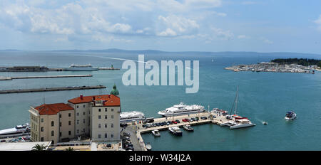 Il lungomare a Split Croazia con barche nel porto e l'isola di Brac in background. Foto Stock