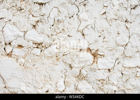 Frammento di un vecchio bianco muro di pietra con grandi pietre e intonaco rotto. Ottimo per la progettazione e la consistenza dello sfondo. Foto Stock