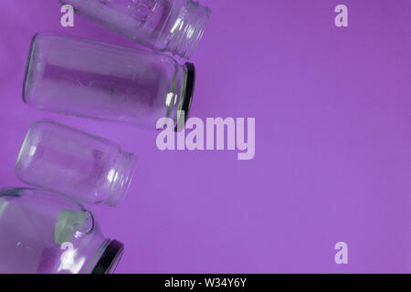 Isolato di vasi in vetro, piatto su viola porpora, sfondo bianco camera vuota per lo spazio per il testo o copiare sulla destra. Programma di riciclaggio o immagine campagna con Foto Stock