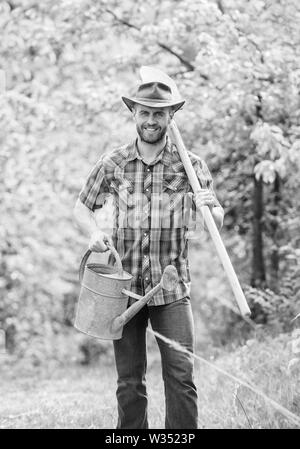 La coltivazione di piante. Coppia guy cappello da cowboy con annaffiatoio e pala. Arbor Day. La piantagione di alberi. Impegno e responsabilità. Concetto di agricoltura. La semina in giardino. La piantumazione di alberi di tradizione. Foto Stock