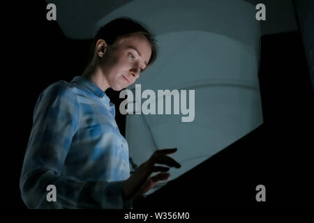 Donna con display touchscreen interattivo al moderno museo di storia Foto Stock