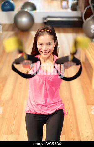 Fitness training sospensione donna escissione in palestra. Donna asiatica facendo forza esercitarsi nel centro fitness. Foto Stock