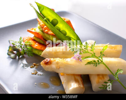 Asparagi bianchi freschi raccolti nel marchfeld austria, e cucinato come un piatto con la salsa e seet baccelli di piselli Foto Stock