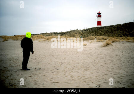 Sylt, Germania. 19 Feb, 2019. Una spiaggia walker sorge sulla spiaggia di fronte al faro List-Ost sull'isola di Sylt. Sylt è la più grande del nord Isola Frisone in Germania. Credito: Britta Pedersen/dpa-Zentralbild/ZB/dpa/Alamy Live News Foto Stock