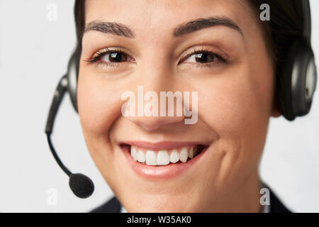 Ritratto di imprenditrice indossando cuffia telefonica nel Dipartimento di Servizio clienti Foto Stock